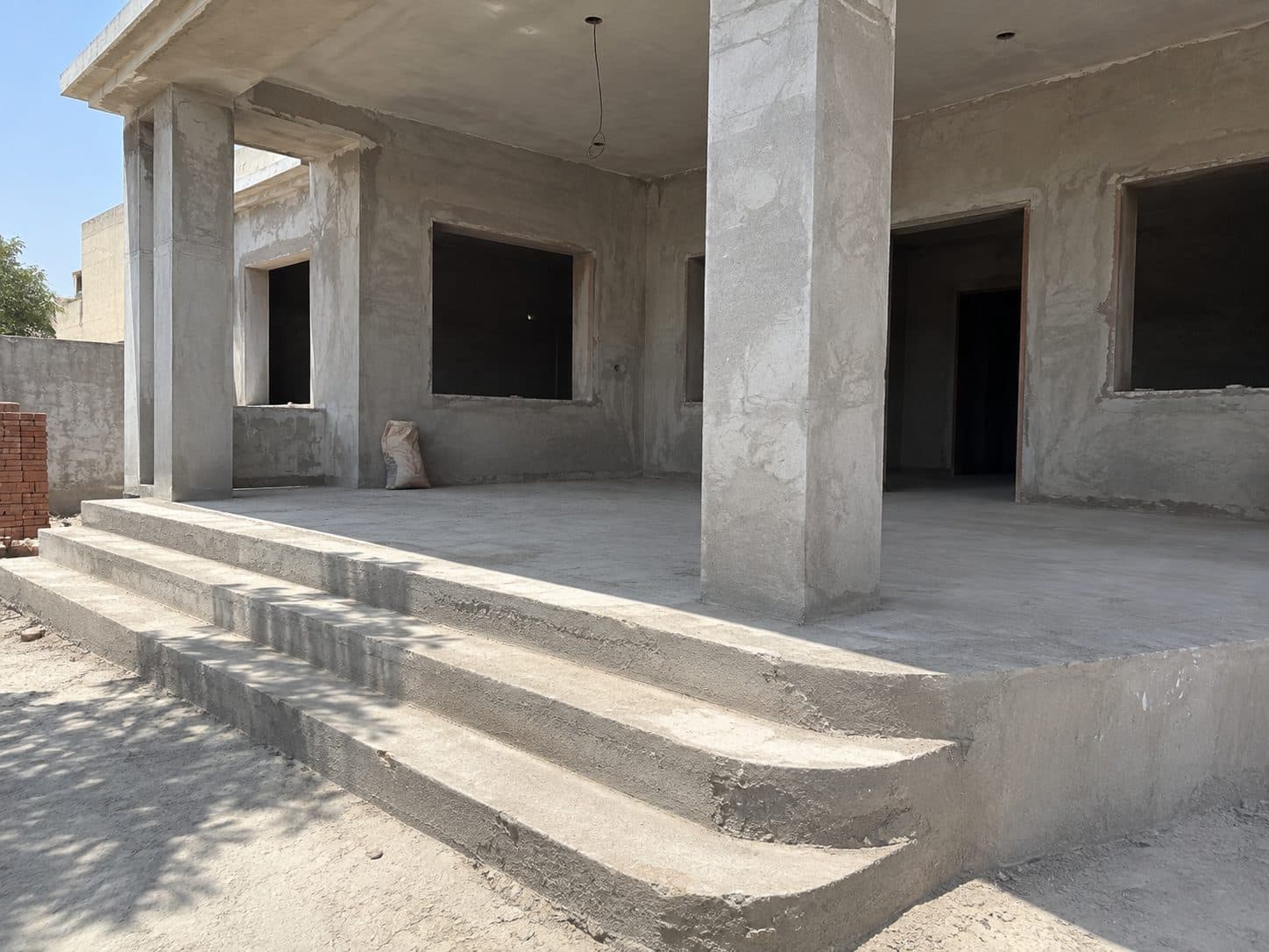 A porch in bare grey concrete, before any stone is laid
